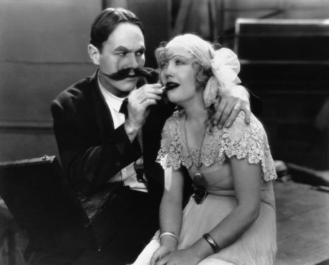 William Haines gives beauty tips to Marian Davies. Image: lkasdfj laksdjf